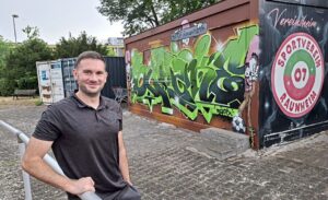 Kenan Yildirim vor den Containern des SV 07 im Sportpark – auf dem Verkaufscontainer der Schriftzug „Vereinsheim" und das Vereinswappen