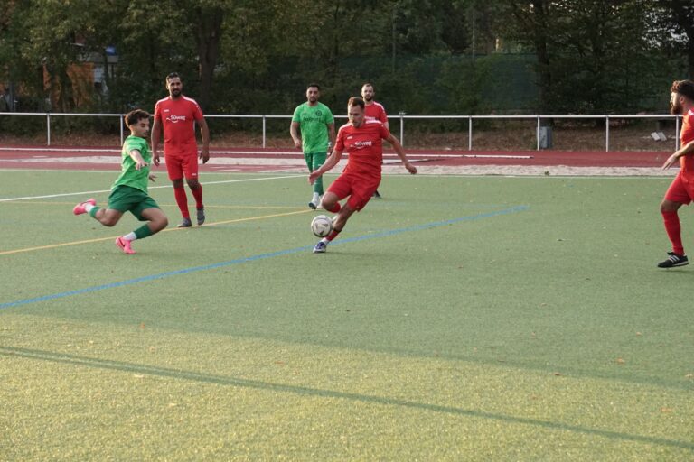 Spielszene im Kreispokal: Spieler des SV 07 Raunheim in Rot im Abschluss zwischen zwei Rüsselsheimer Gegenspielern