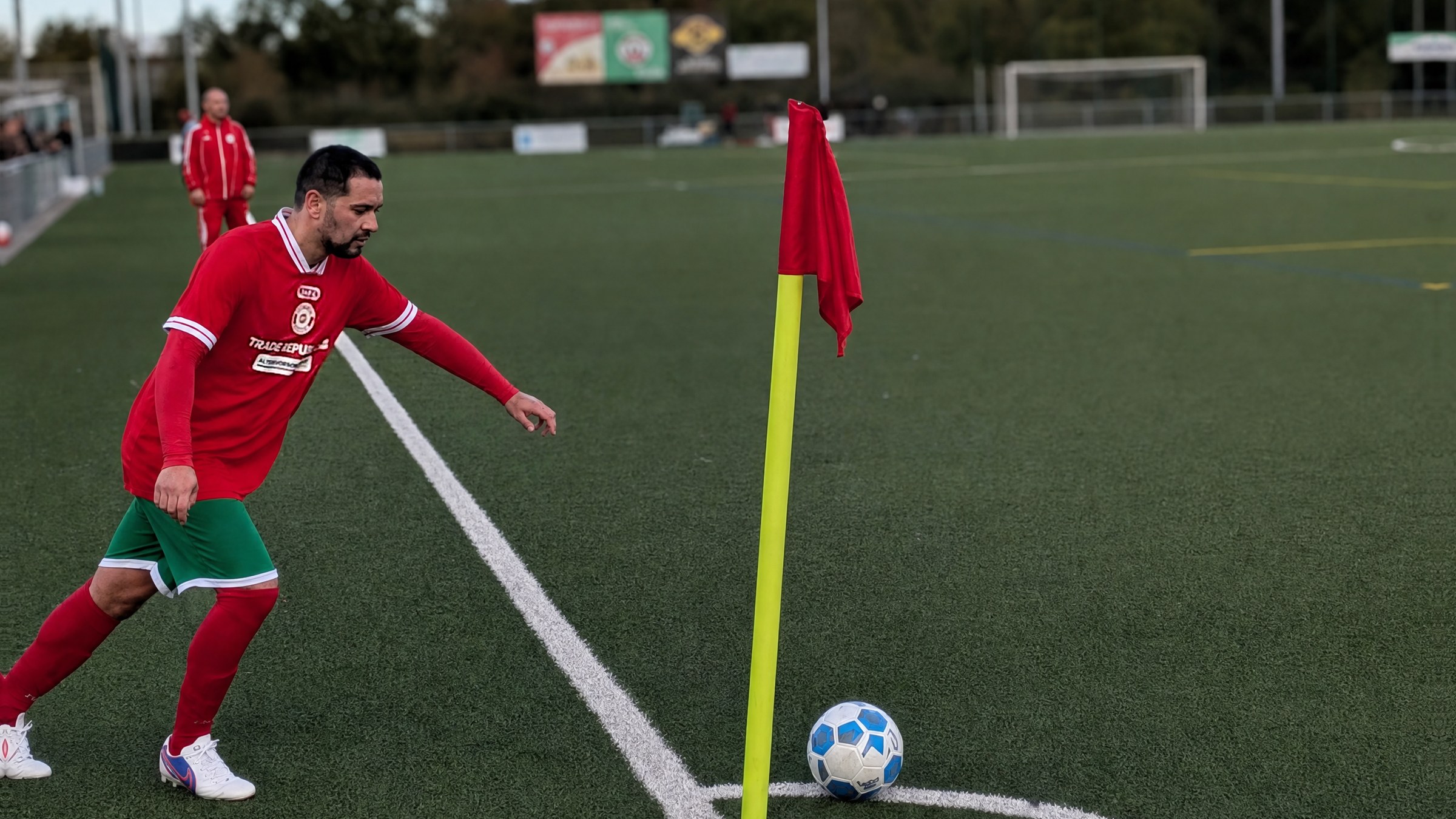 Spieler des SV 07 Raunheim im roten Trikot beim Eckstoß an der Eckfahne, der Ball liegt im Viertelkreis